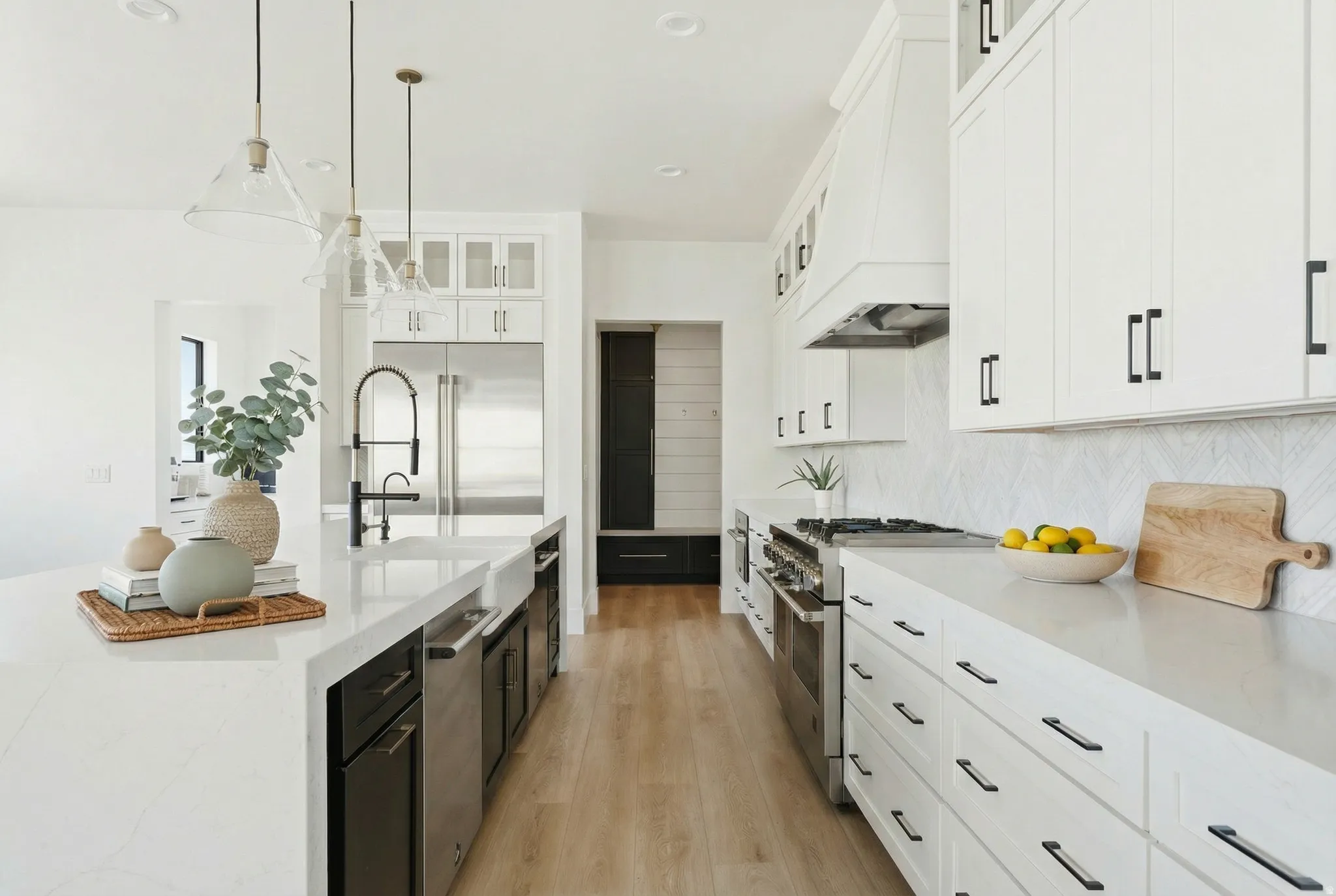 Kitchen featuring light stone countertops, glass insert cabinets, high end appliances, dark cabinets, and pendant lighting - Digitally Staged