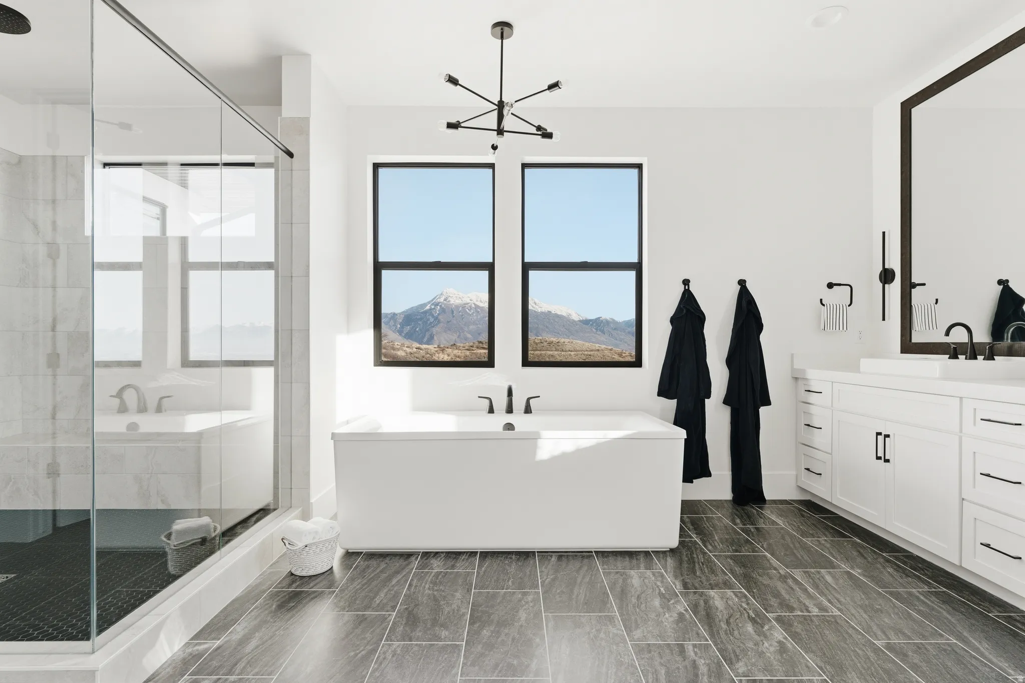 Full bath featuring a bath, a shower stall, vanity, and suspended lighting