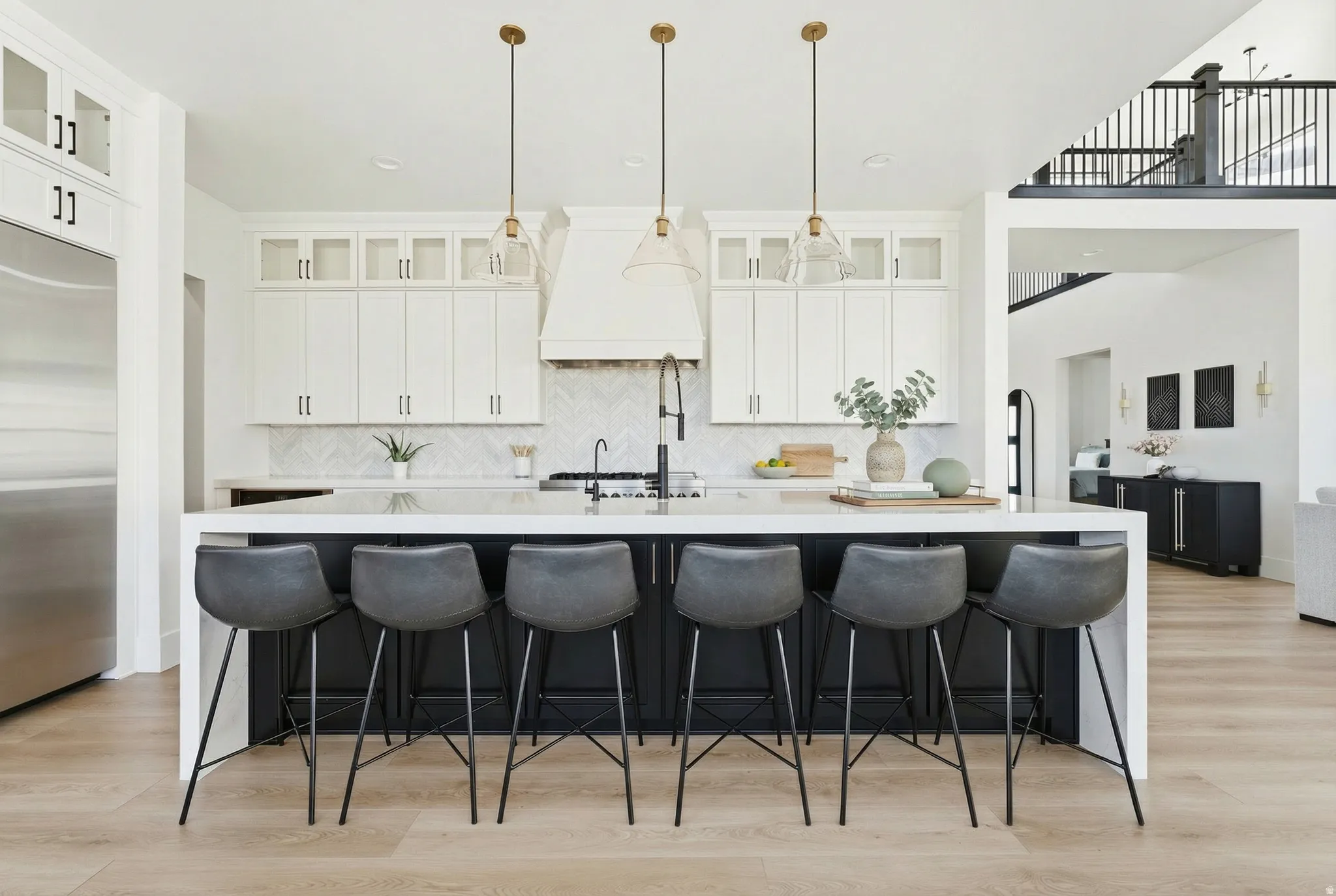 Kitchen featuring glass insert cabinets, white cabinets, light wood finished floors, a breakfast bar, and recessed lighting - Digitally Staged