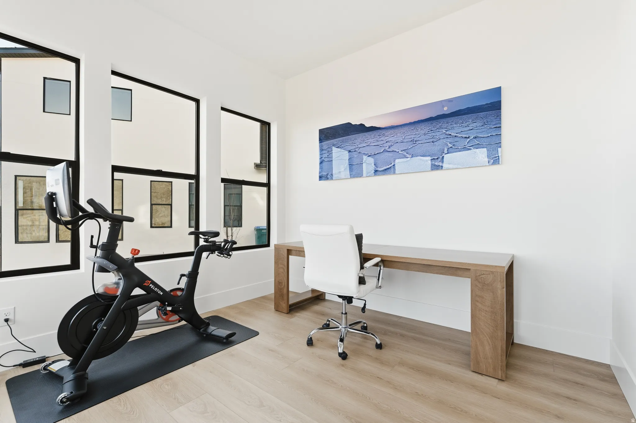 Office with light wood-type flooring and baseboards