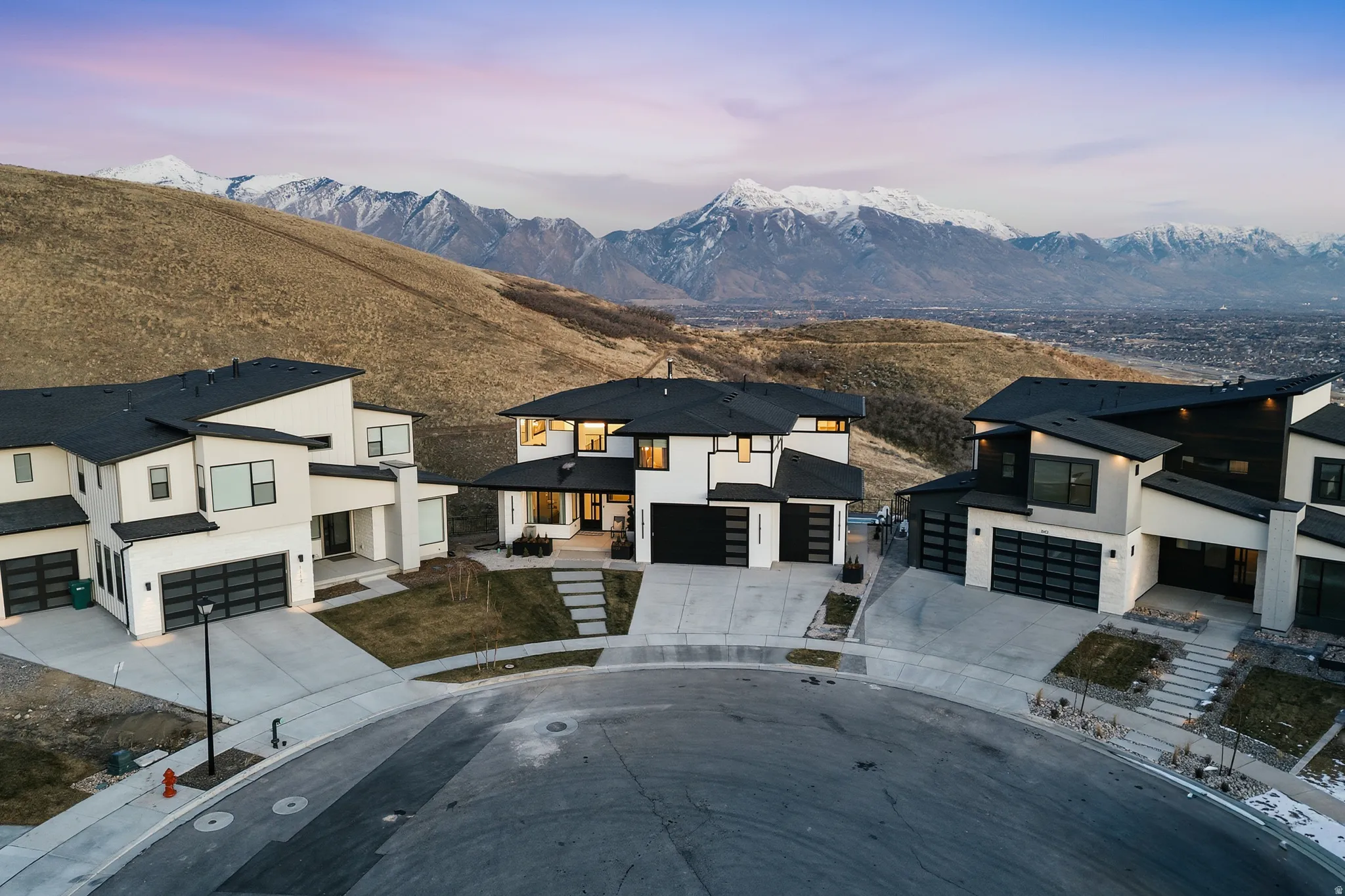 View of front of home with driveway, stucco siding, a patio area, and a garage