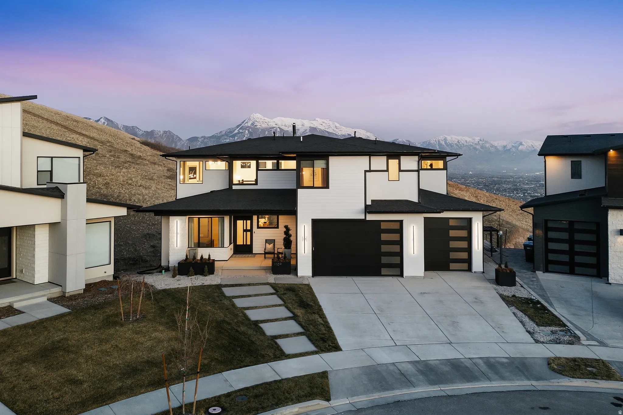 View of front facade featuring a mountain view, concrete driveway, roof with shingles, an attached garage, and a porch