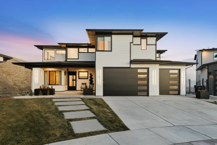 Contemporary house with covered porch, driveway, and an attached garage