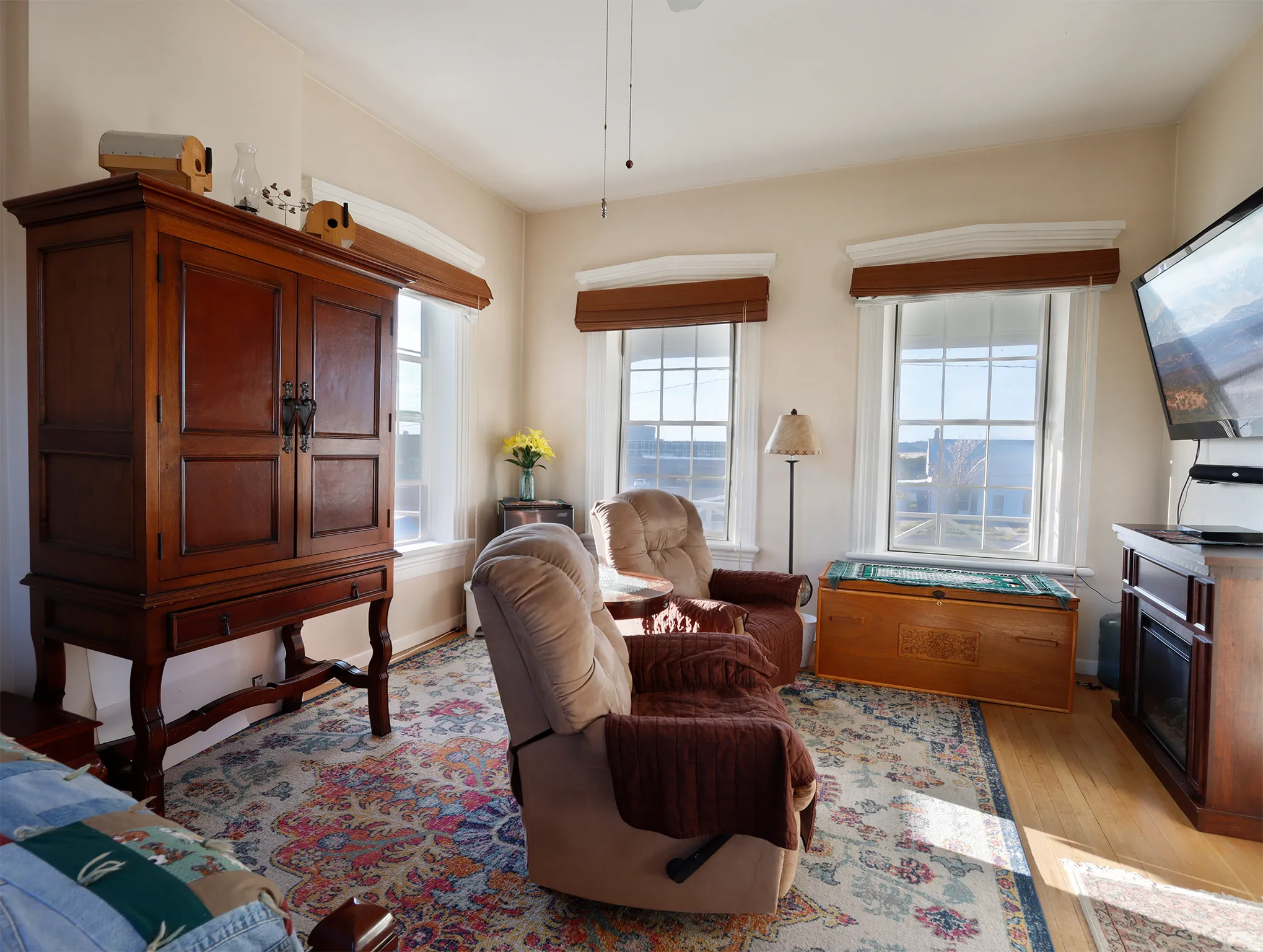 Living area featuring hardwood flooring and multiple windows with blinds