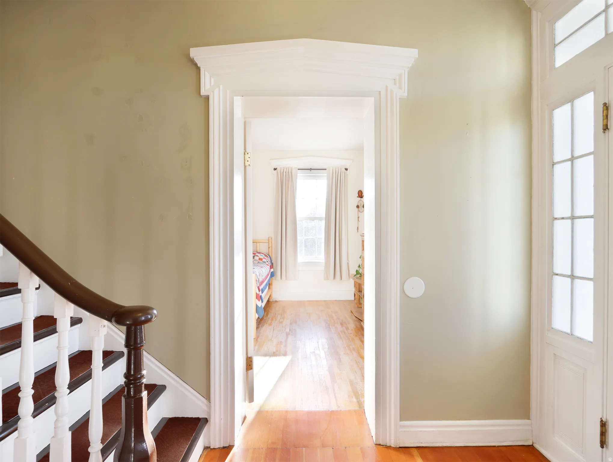 Hardwood flooring extends throughout this interior space, featuring a decorative door frame with molding