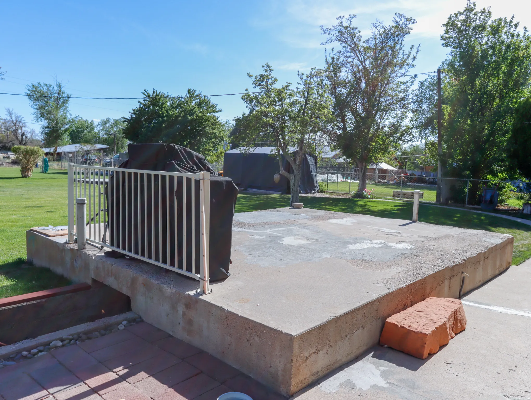 Expansive concrete patio area with a white metal railing