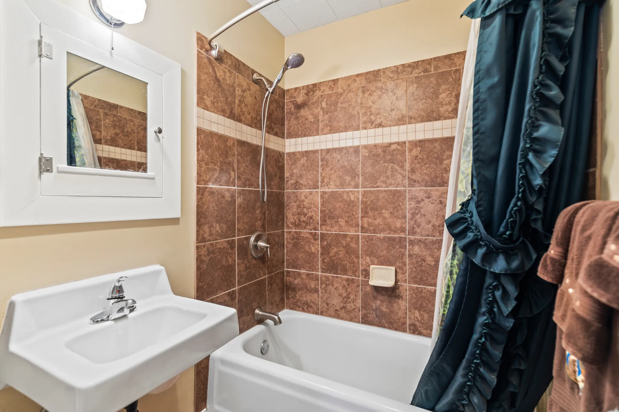 Bathroom featuring shower / bath combo and a sink
