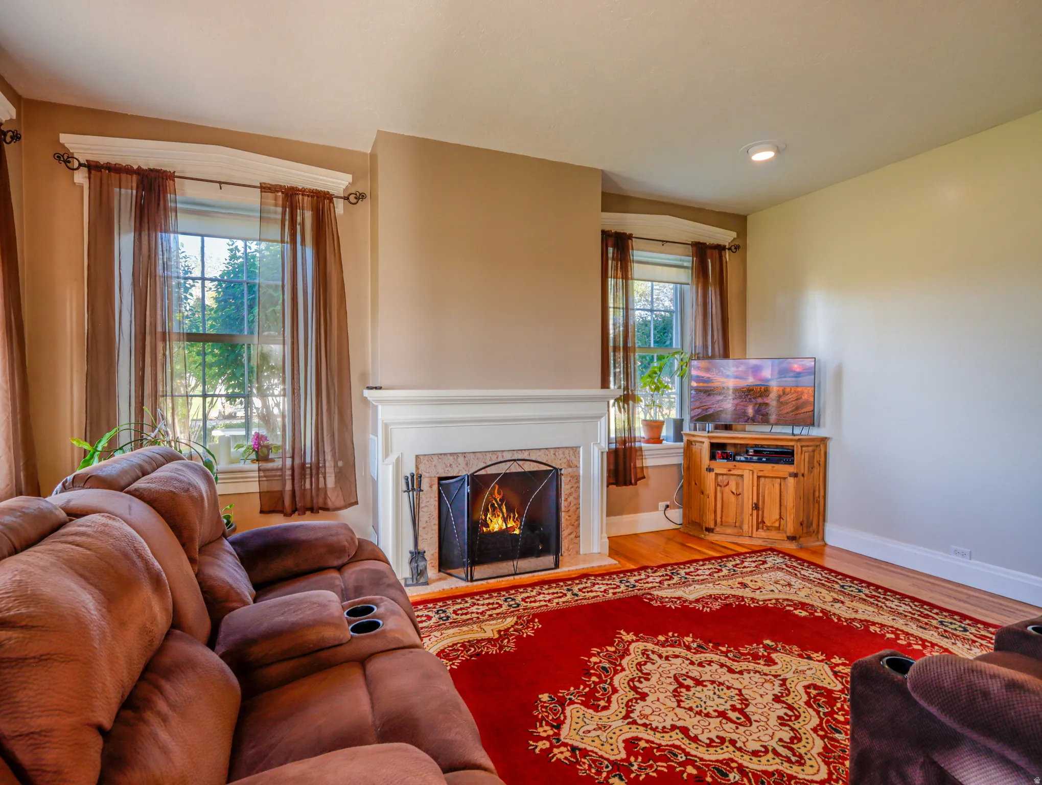 Living area featuring a fireplace with a white mantel, stone surround, and hearth