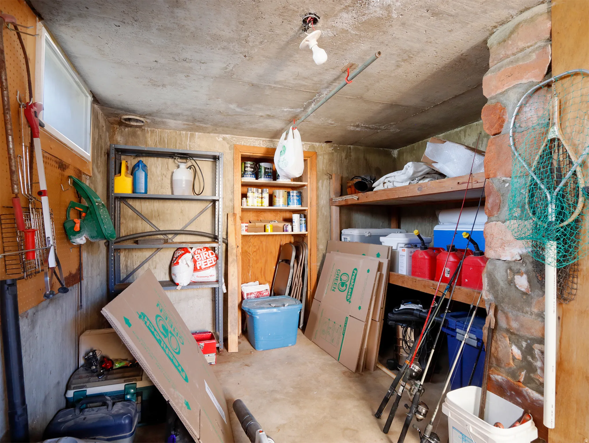 Utility room featuring concrete flooring and a partial exposed stone wall