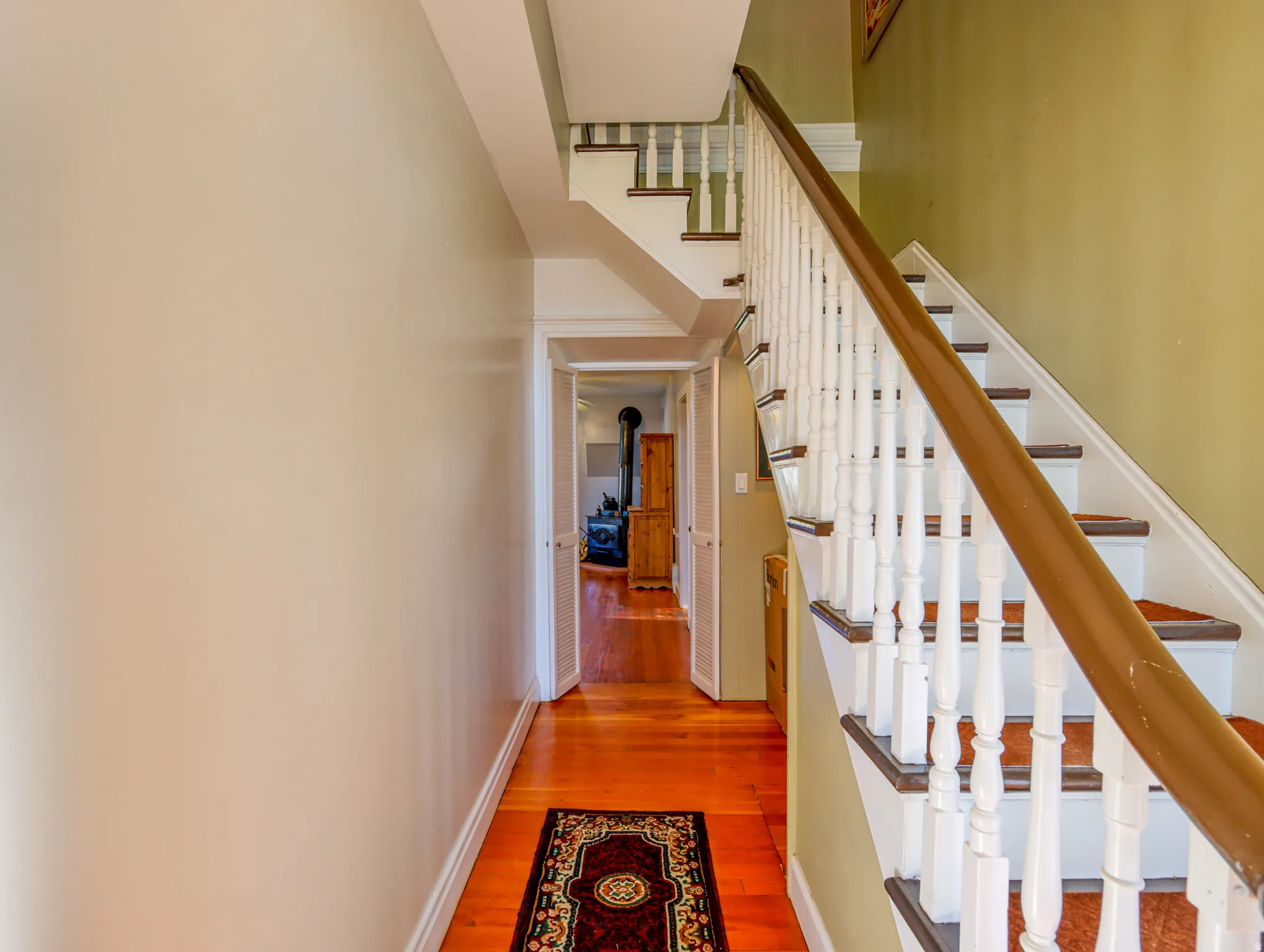 Hardwood flooring in a rich cherry finish extending through a hallway