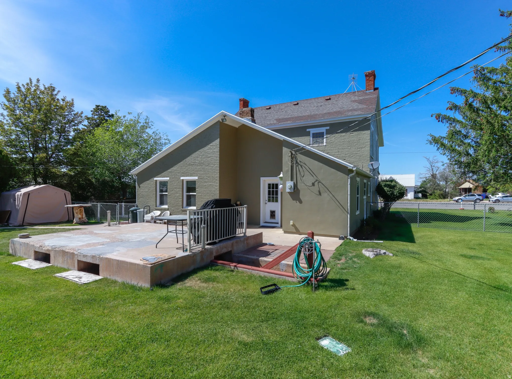Expansive concrete patio with white metal railing, featuring direct exterior access