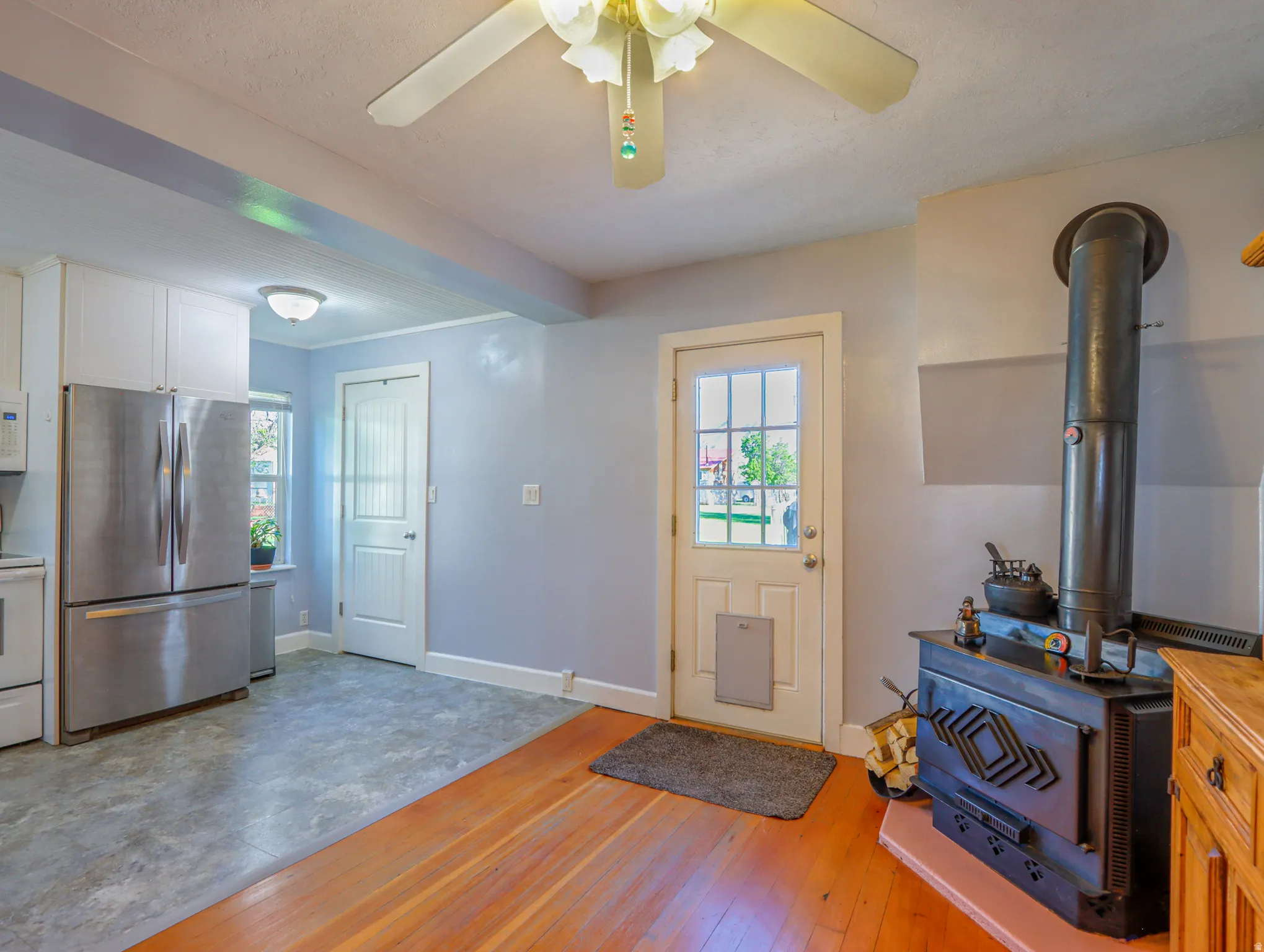 Wood-finish flooring and a corner wood-burning stove with a stone hearth