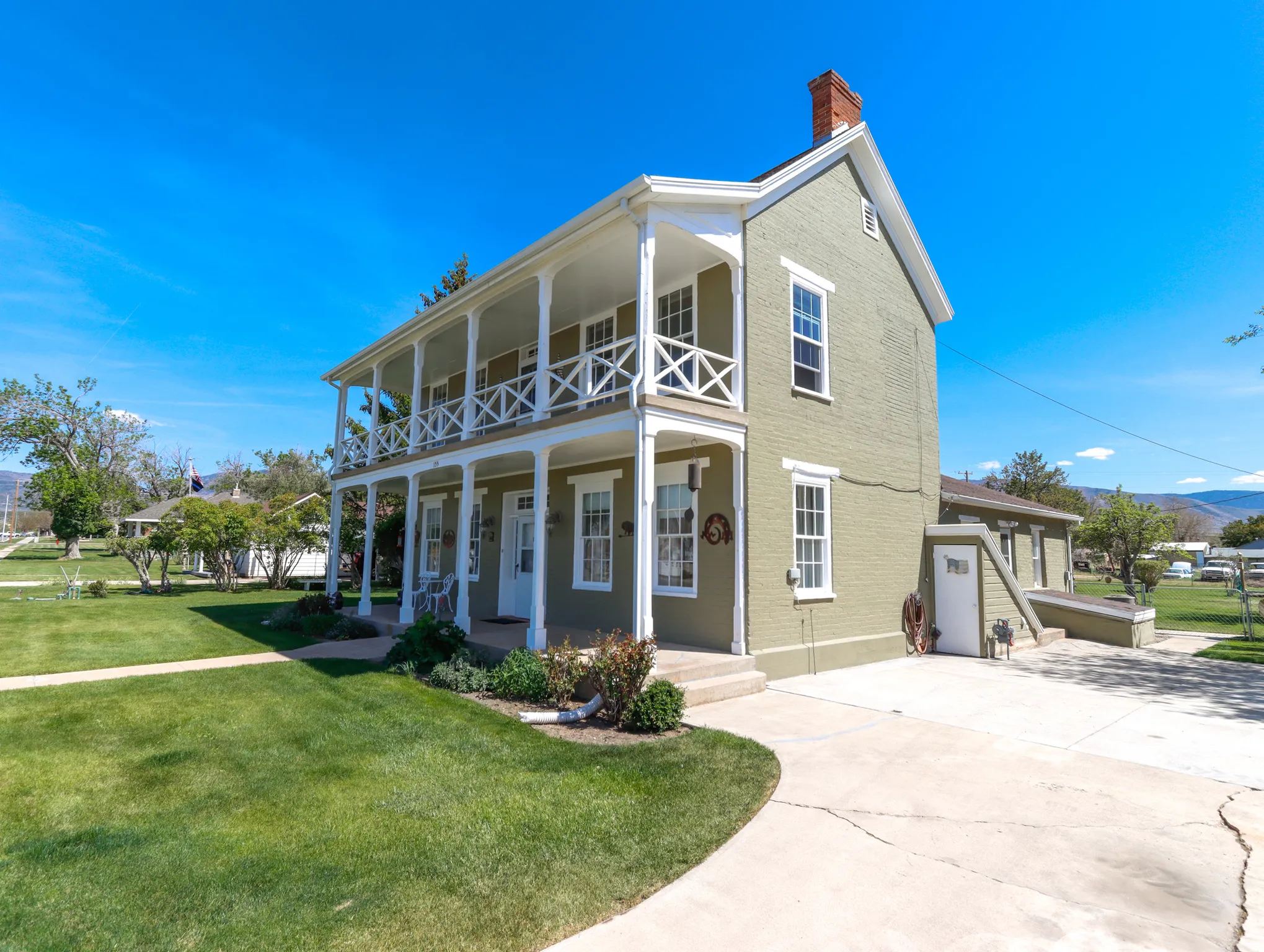 Two-story residence featuring a dual-level covered porch with decorative railings