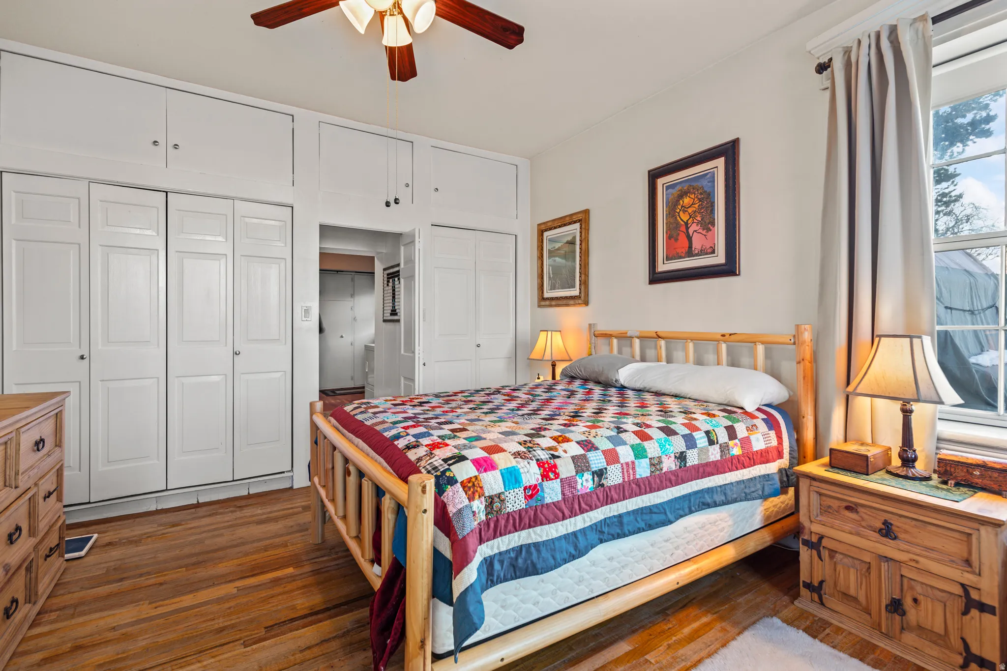 Bedroom with multiple closets, wood-type flooring, and a ceiling fan