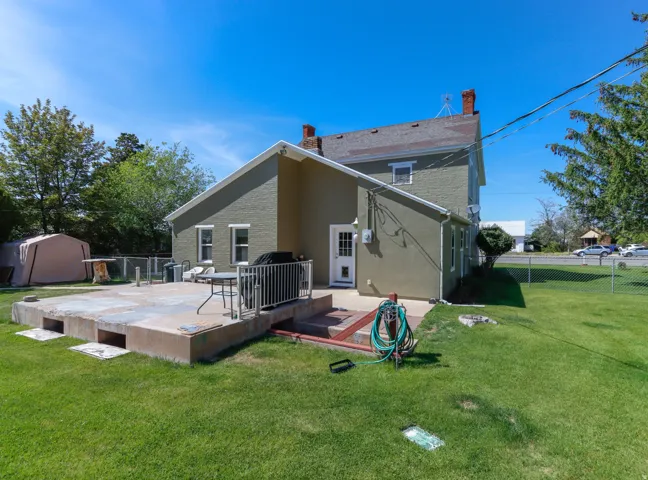 Expansive concrete patio with white metal railing, featuring direct exterior access