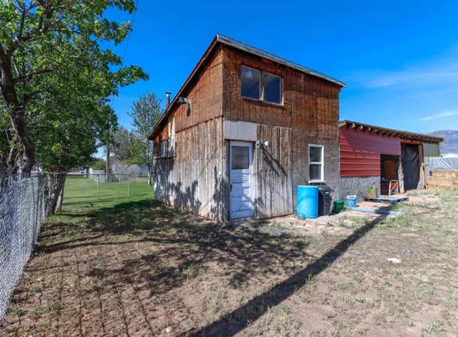 Wood-sided structure with a red corrugated metal extension