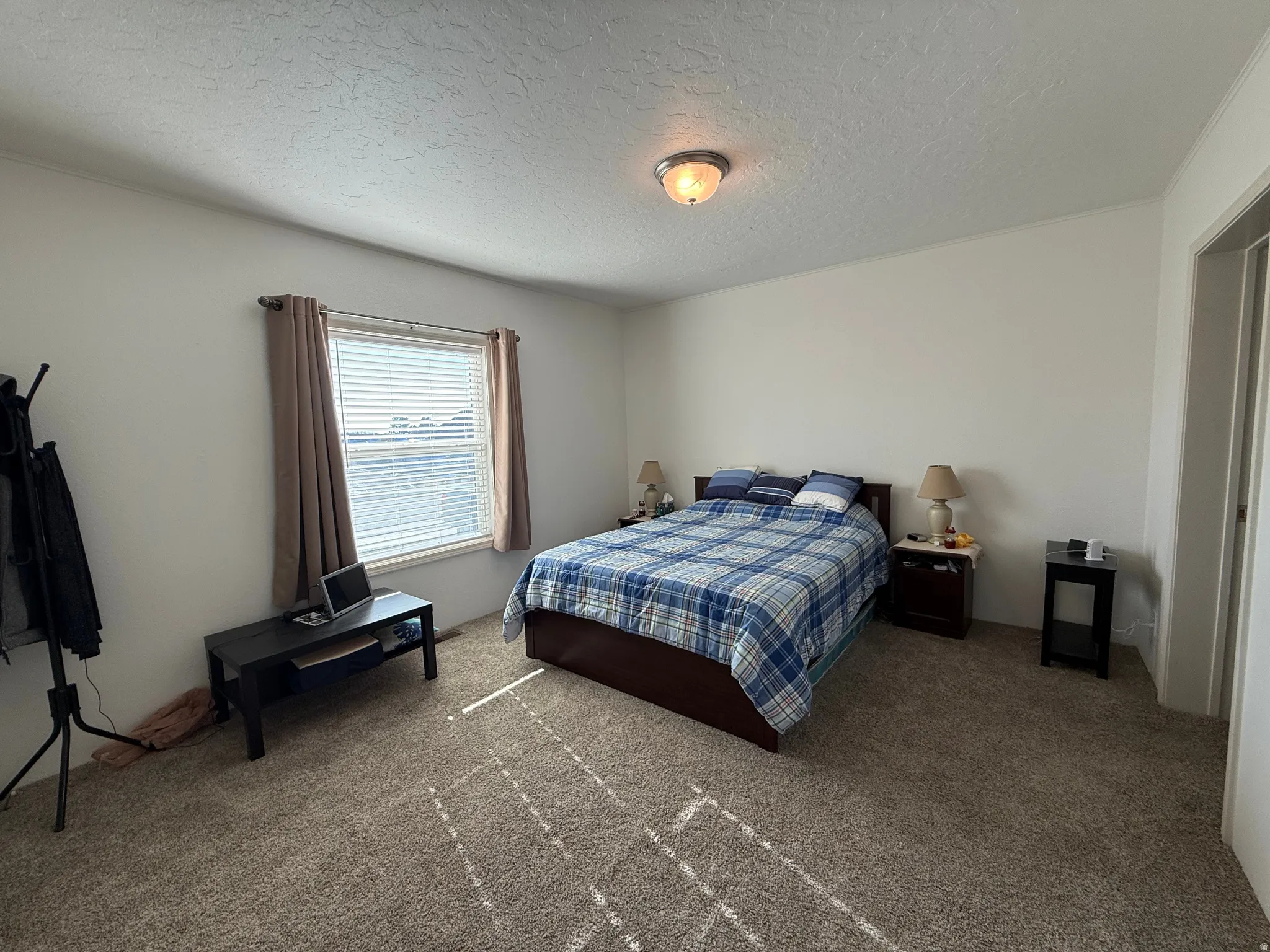 Carpeted bedroom with a textured ceiling