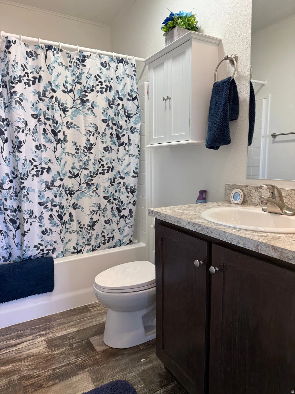 Full bathroom featuring vanity, dark wood finished floors, and shower / tub combo