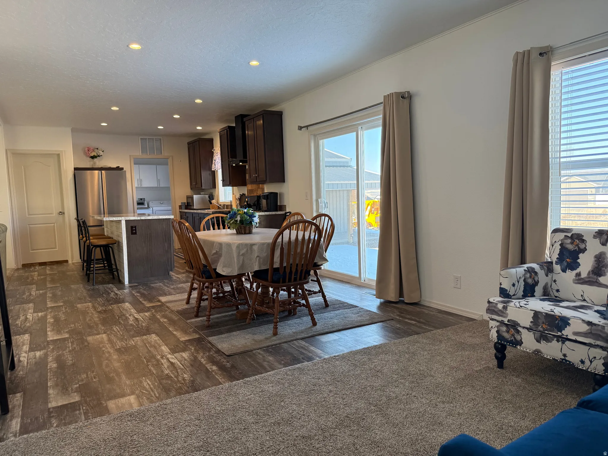 Dining space featuring dark wood-style floors, recessed lighting, a textured ceiling, and washer / dryer