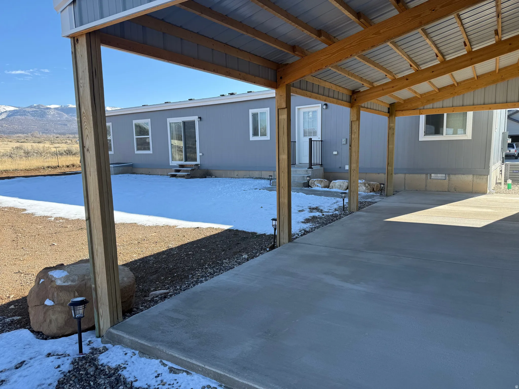 Snow covered patio with entry steps and a mountain view