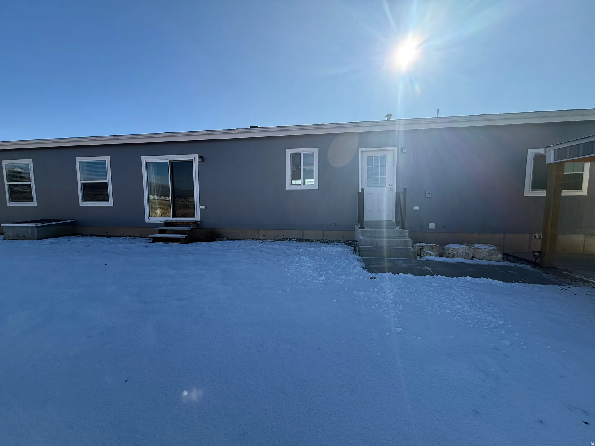 Snow covered property featuring entry steps