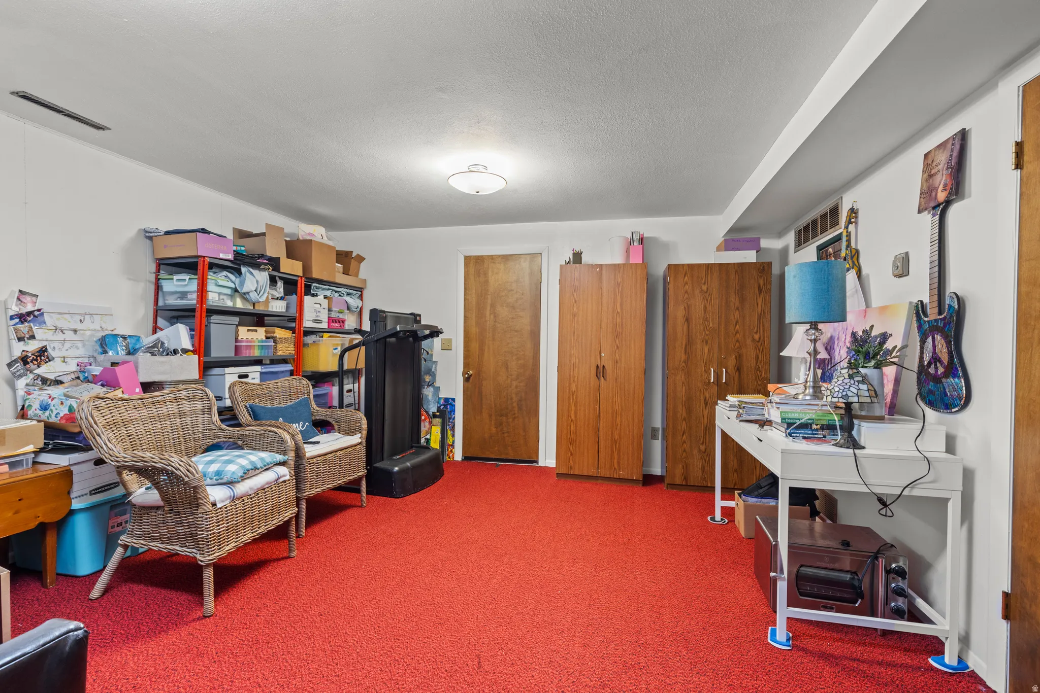Living area featuring carpet and a textured ceiling