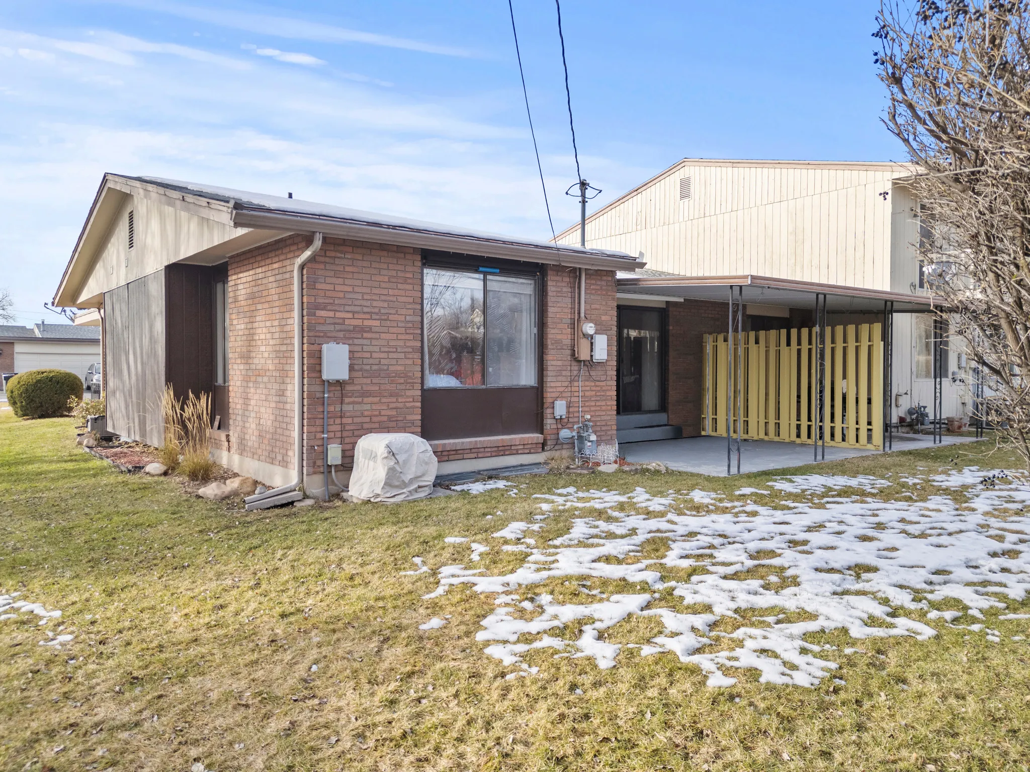 Back of property with brick siding, a patio area, and a yard