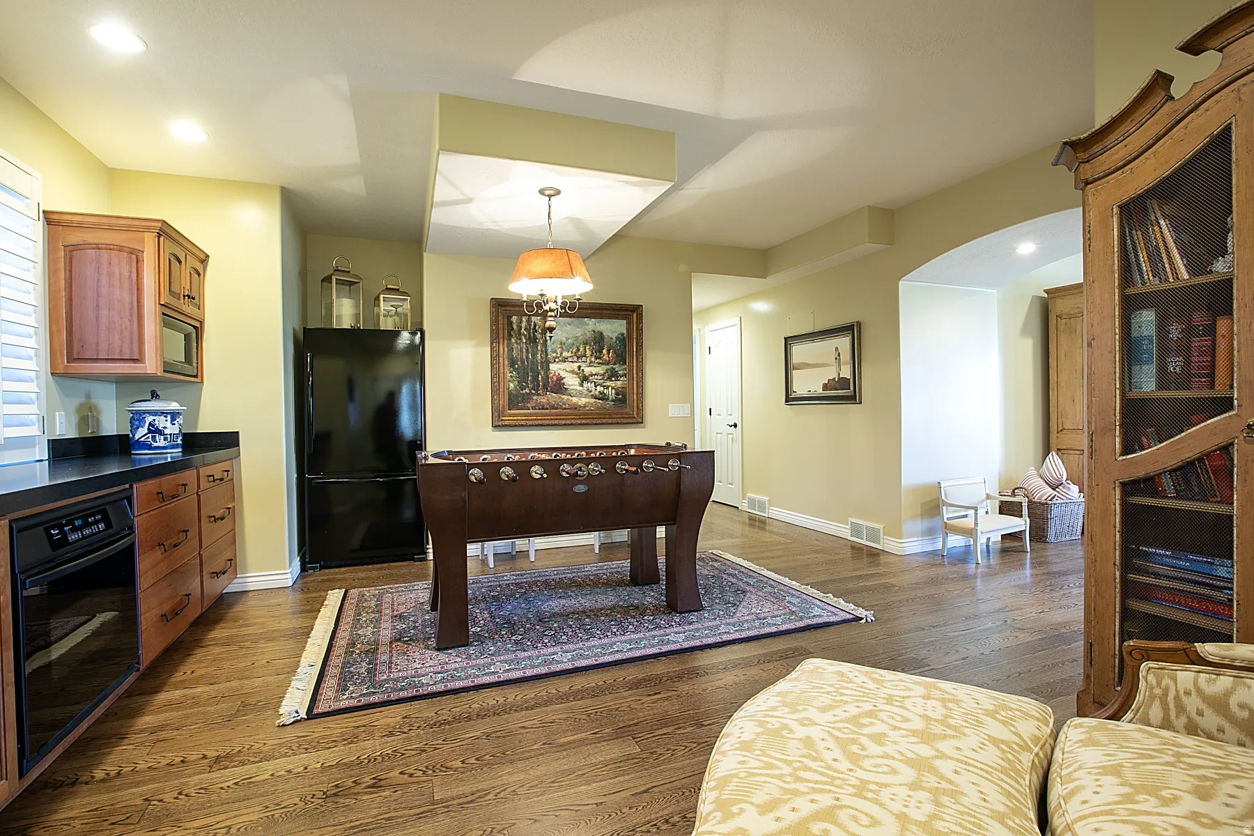 Rec room featuring dark wood-type flooring, recessed lighting, and arched walkways