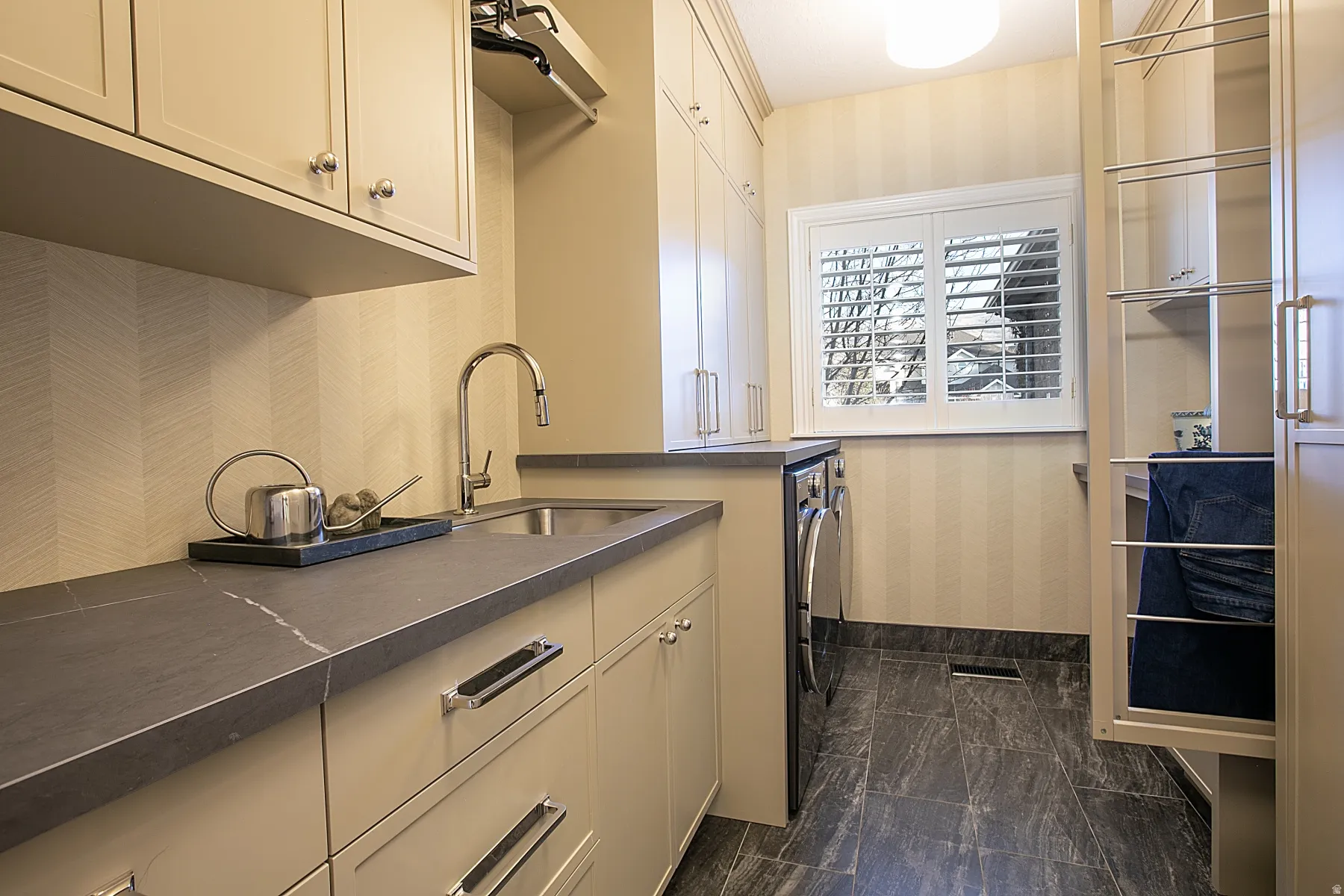 Laundry room with wallpapered walls, cabinet space, and independent washer and dryer