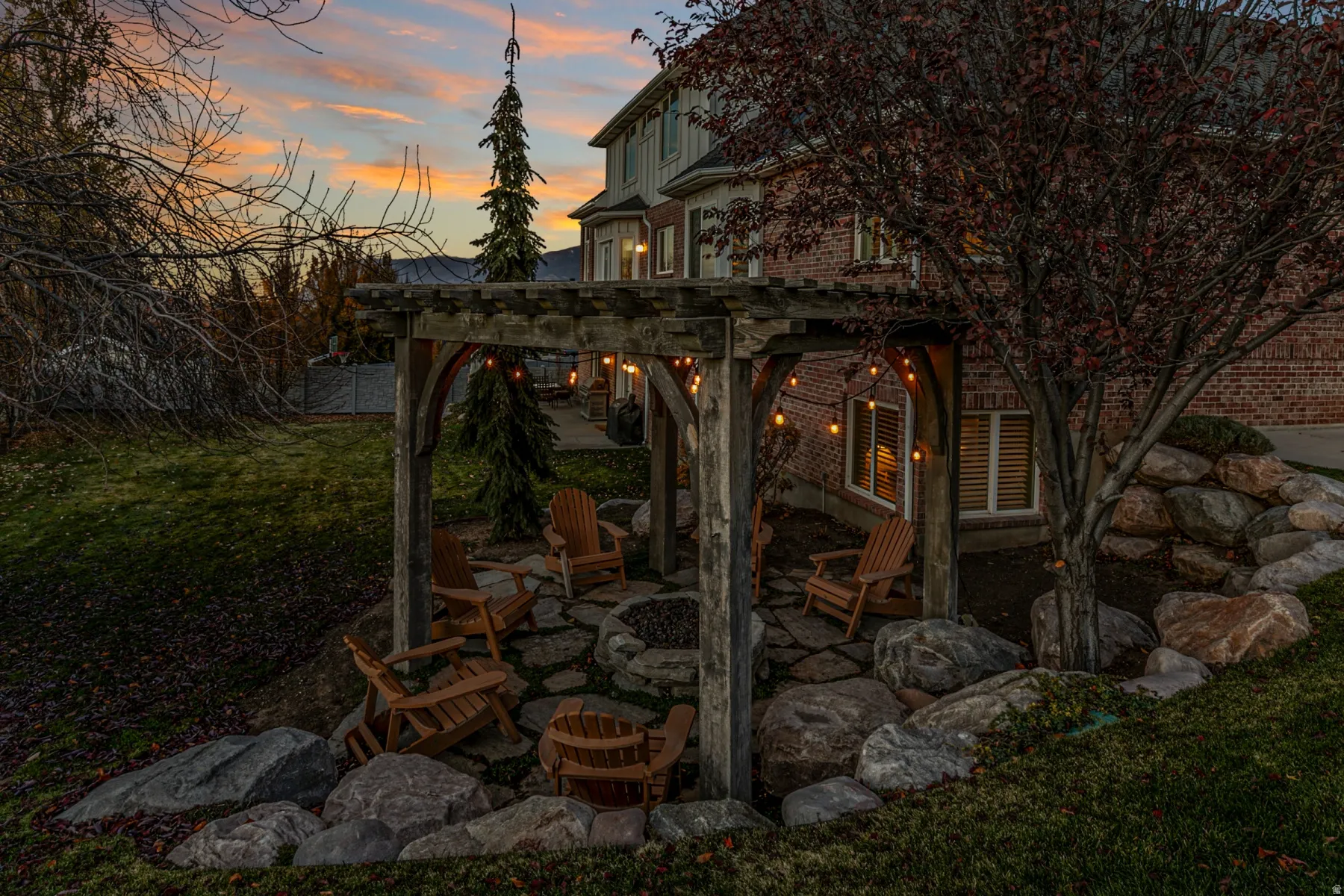 Patio terrace at dusk with a pergola, a fire pit, a patio area, and a yard