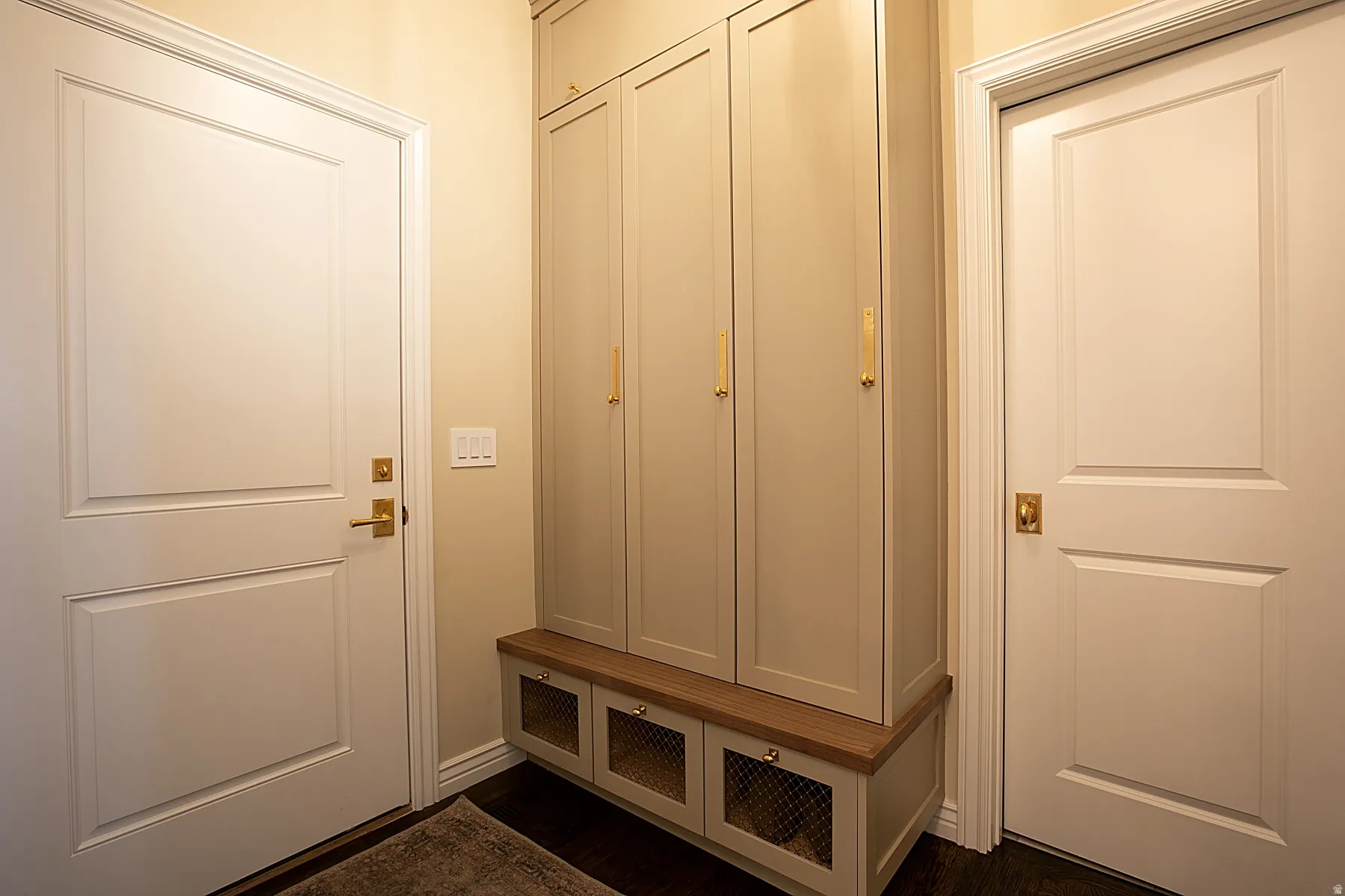Mudroom featuring dark wood-type flooring and baseboards