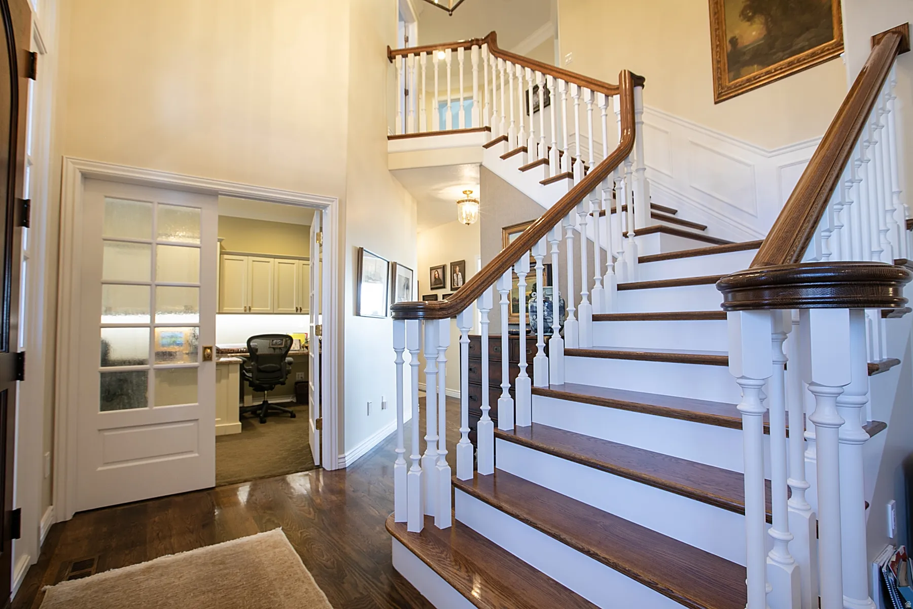 Stairway featuring wood finished floors and a towering ceiling