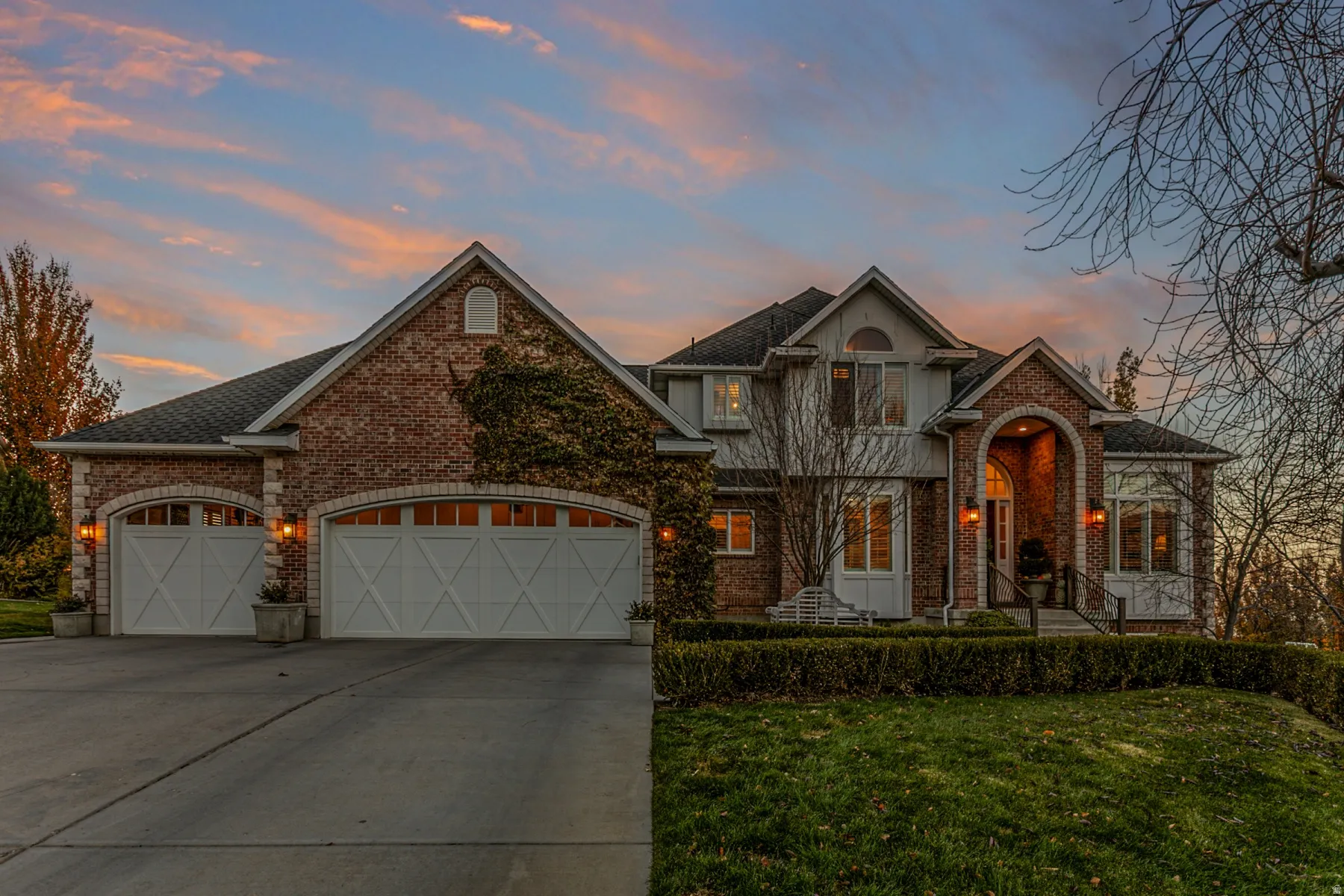 View of front facade featuring a lawn, a garage, driveway
