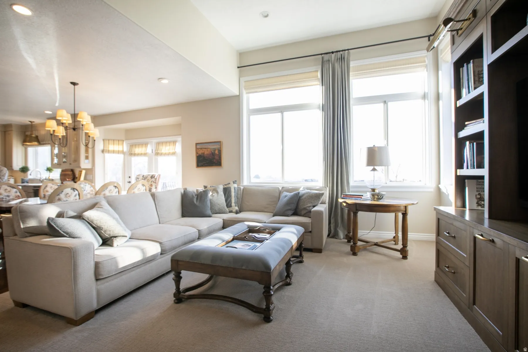 Living room with light colored carpet, a chandelier, and recessed lighting