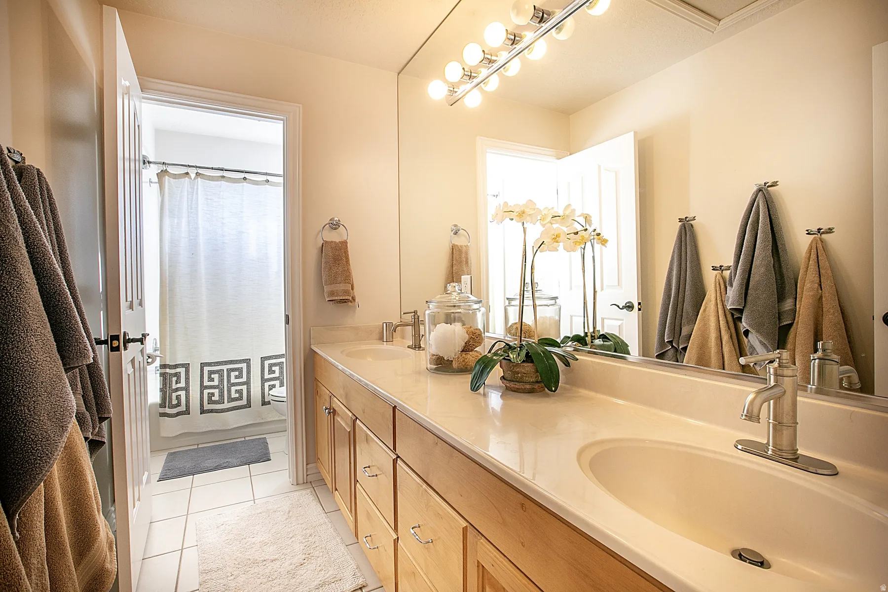 Bathroom featuring double vanity and light tile patterned flooring