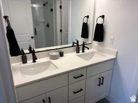 Full bath with double vanity and a stall shower