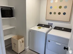 Laundry area featuring light tile patterned flooring and washing machine and dryer