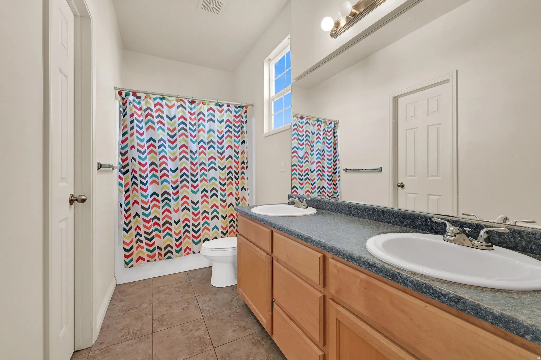 Full bath featuring double vanity