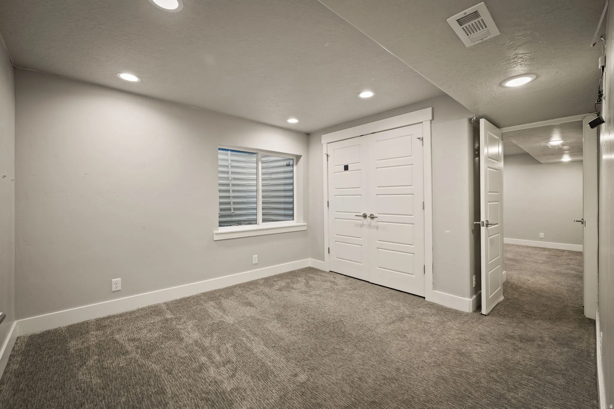Unfurnished bedroom featuring carpet floors, a closet, a textured ceiling, and recessed lighting