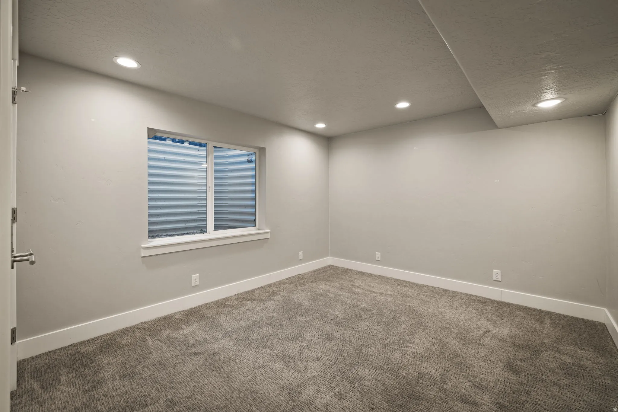 Carpeted spare room featuring recessed lighting and a textured ceiling