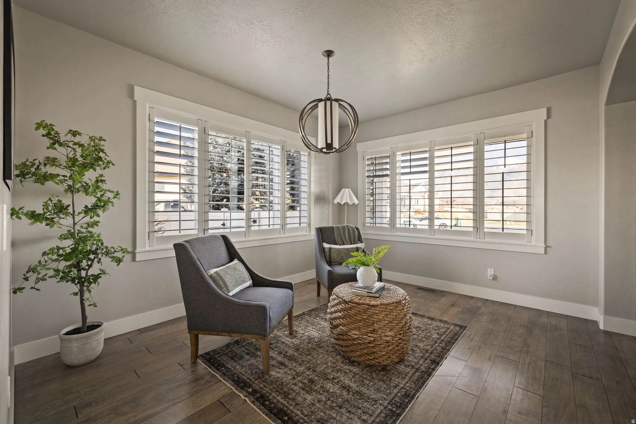 Sitting room featuring dark wood-type flooring and a textured ceiling