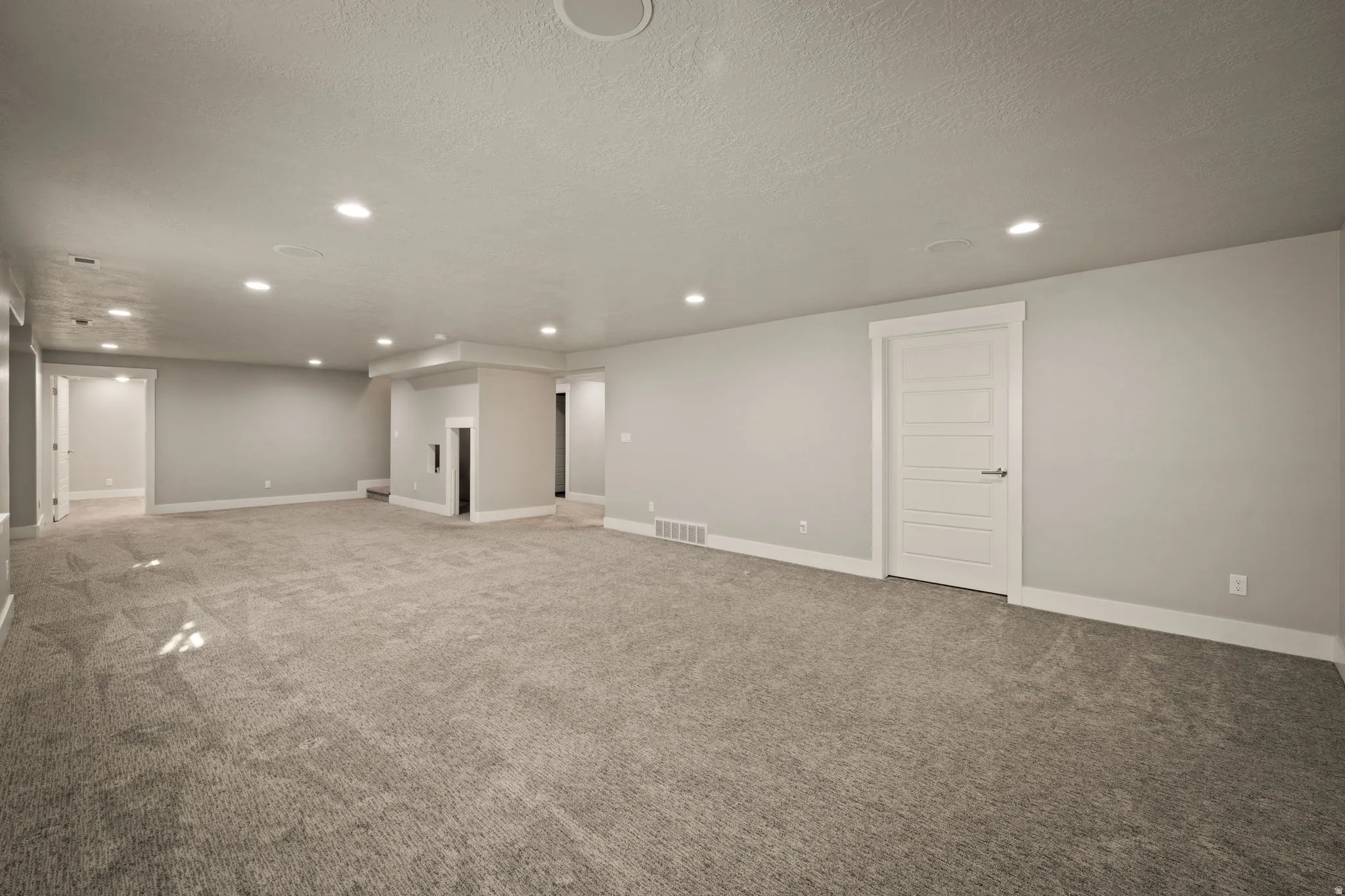 Below grade area with recessed lighting, carpet flooring, and a textured ceiling