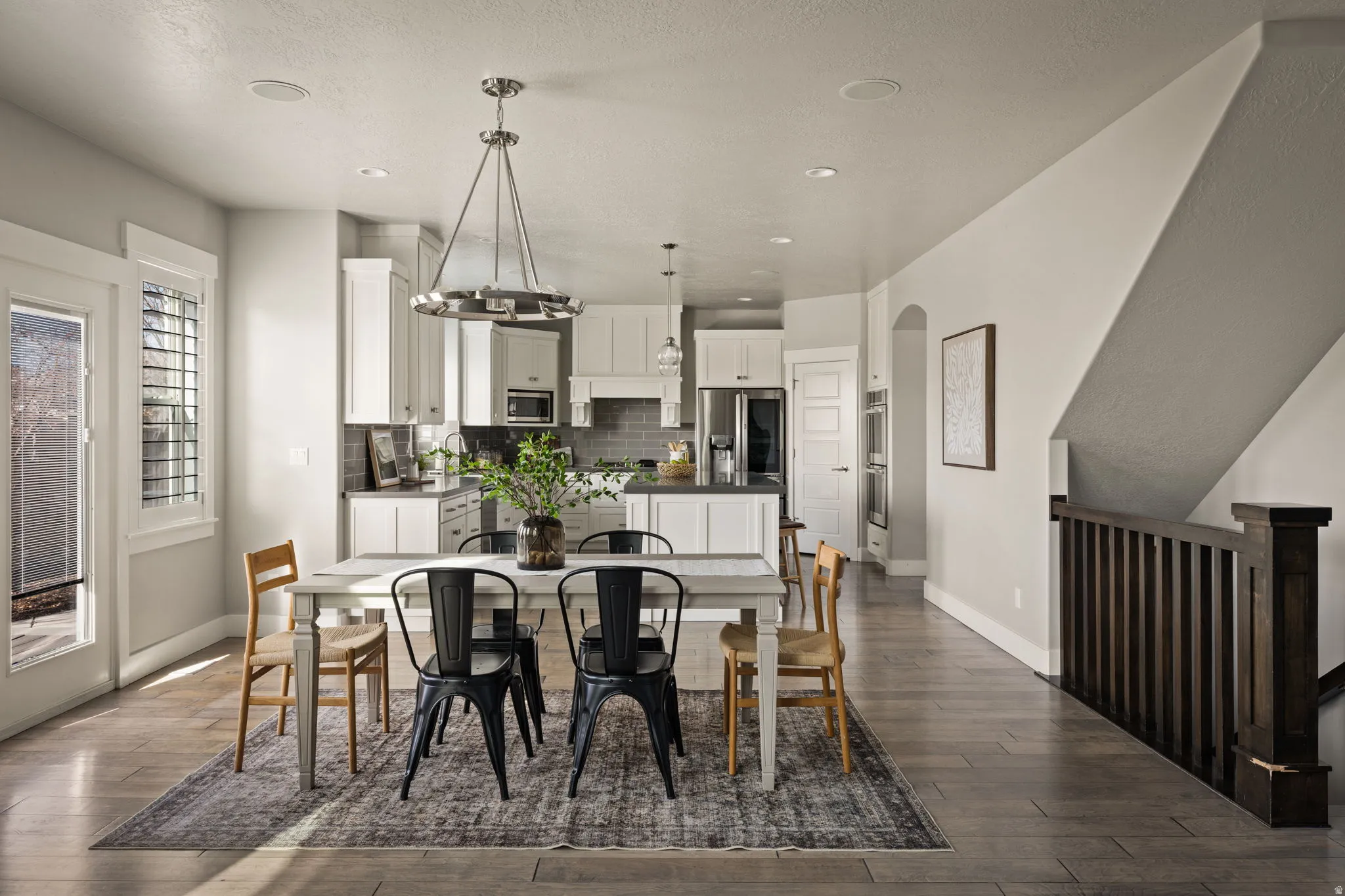 Dining room with dark wood-style floors and arched walkways