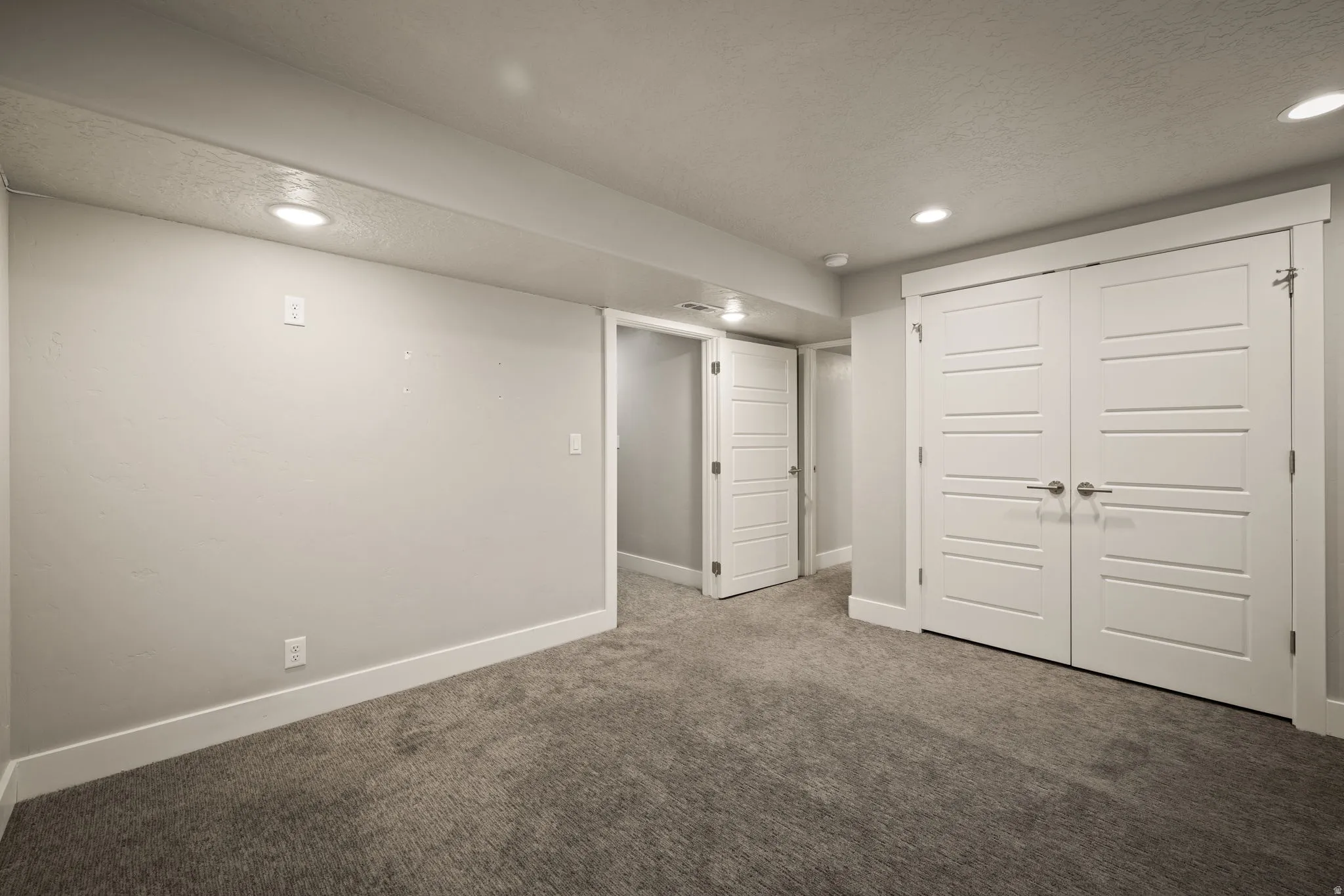 Finished below grade area featuring carpet, recessed lighting, and a textured ceiling