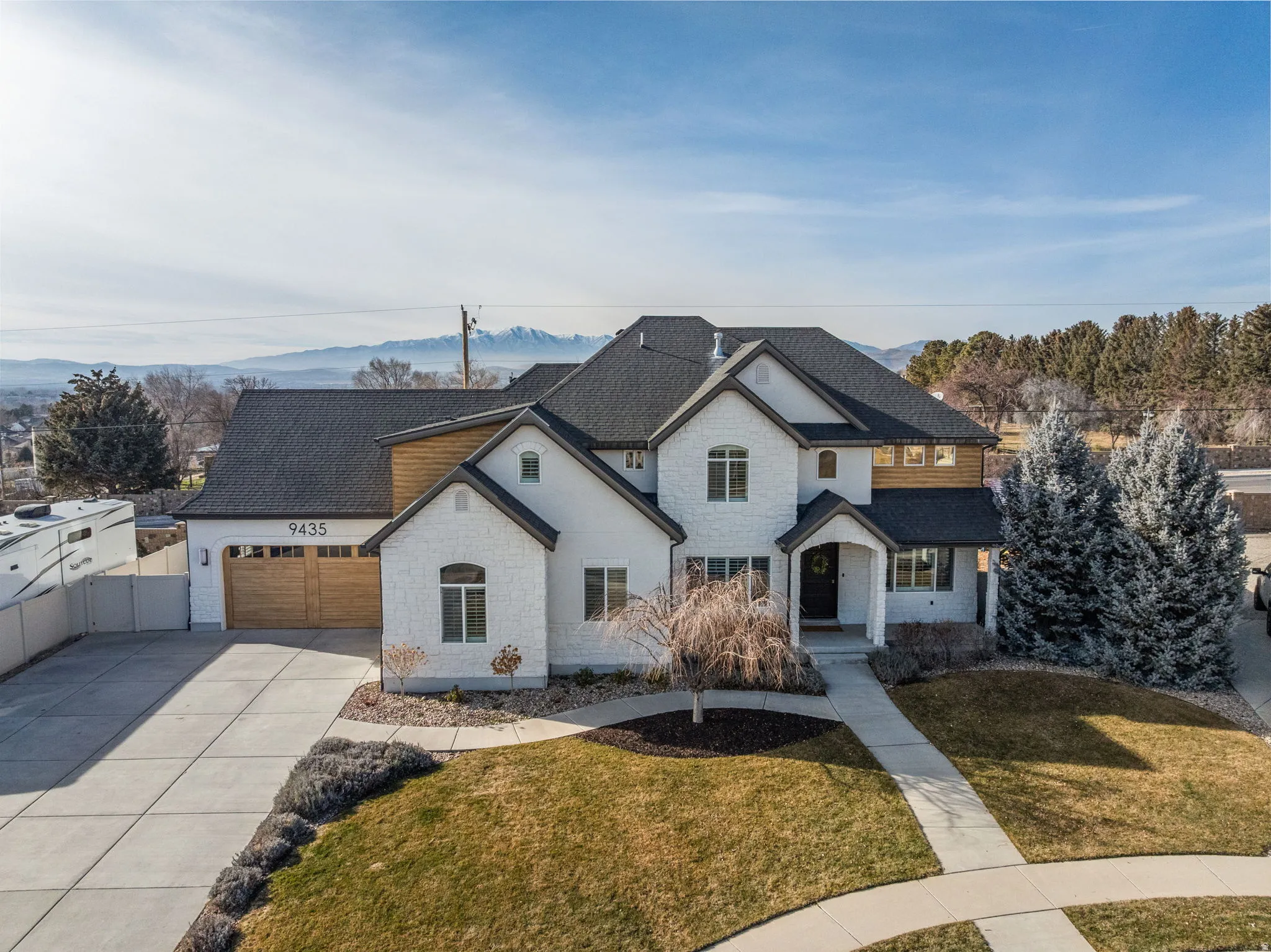 French provincial home with driveway, a shingled roof, stone siding, and an attached garage