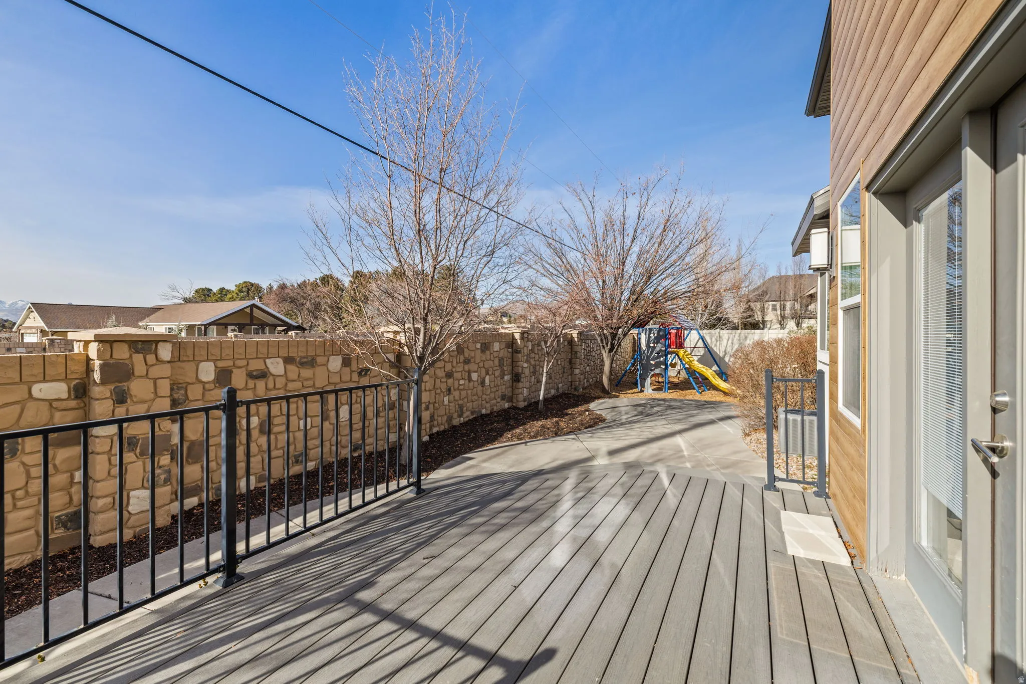 Deck with a playground, a fenced backyard, and a residential view