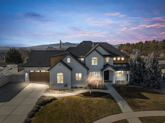 French provincial home featuring driveway, a shingled roof, an attached garage, stone siding, and a mountain view