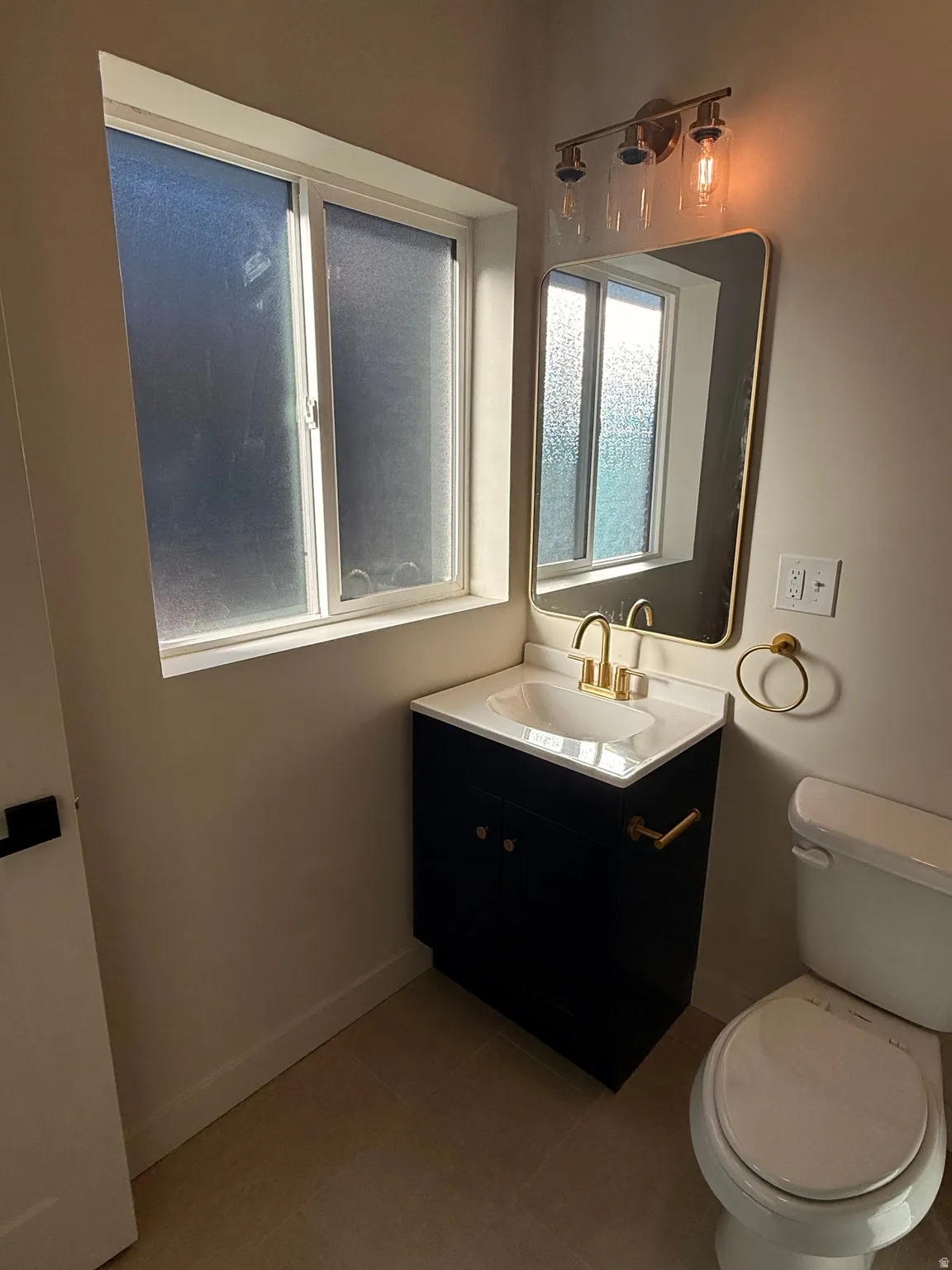 Bathroom with vanity and dark tile patterned floors