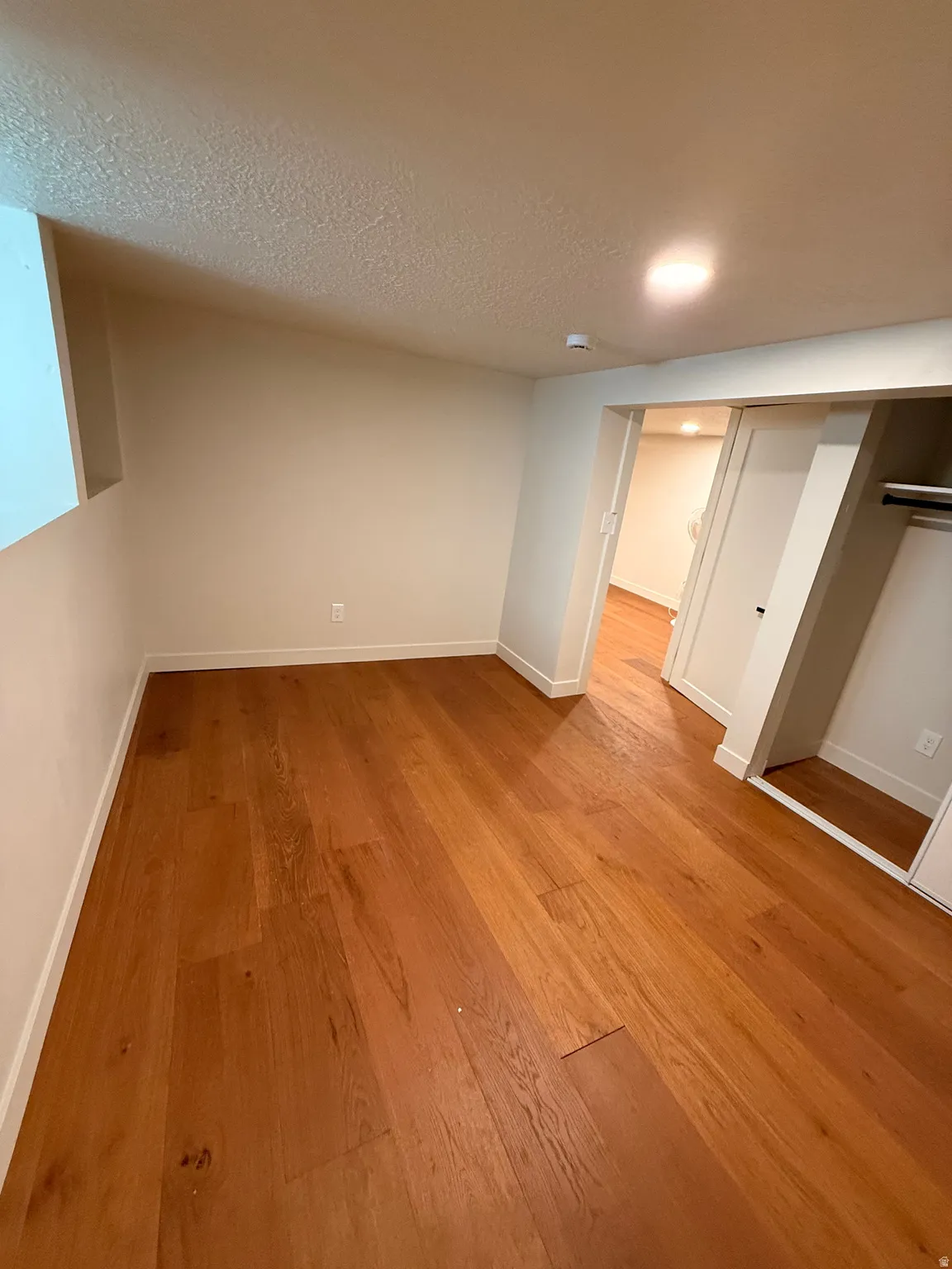 Unfurnished bedroom featuring light wood-style flooring and a textured ceiling