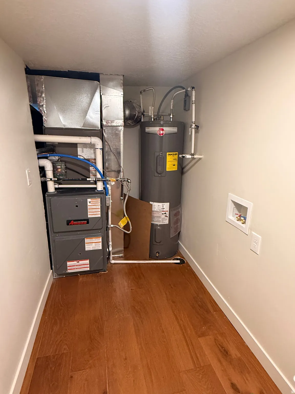 Utility room with heating unit and water heater, washer and dryer hook ups.